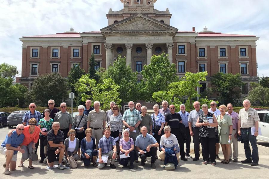 A large group of alumni from the Faculty of Agricultural and Food Sciences stand together in front of the Administration building on the Fort Garry campus.