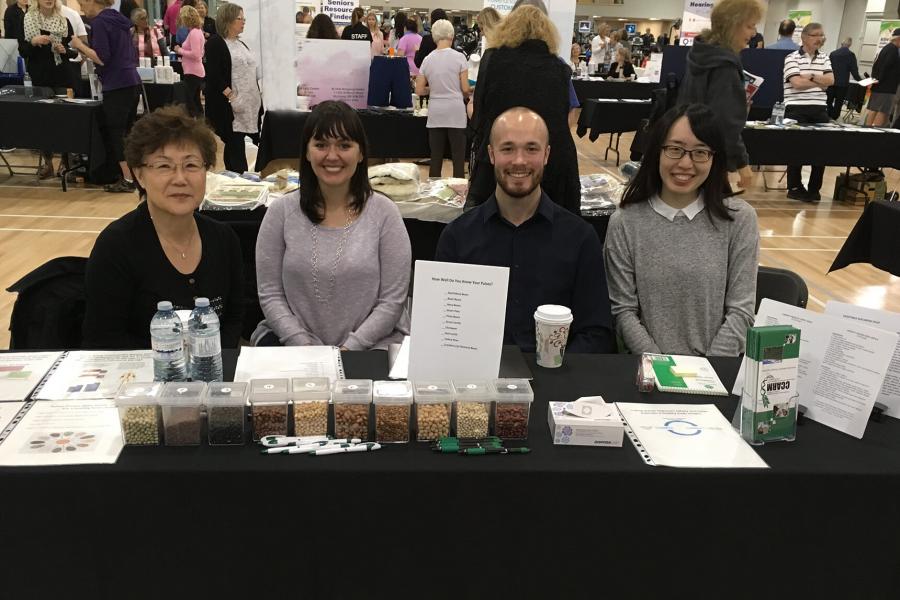 Doctorate students at an outreach event featuring a variety of pulses.