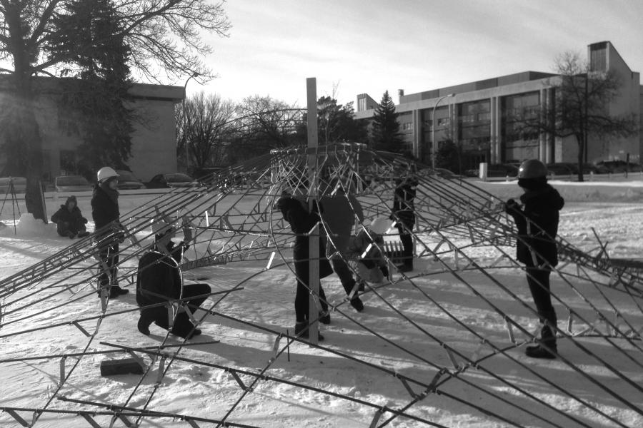student building a sculpture outside in the winter