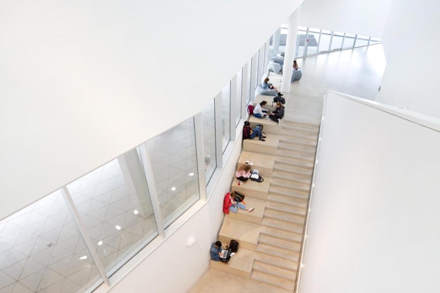 An upper level view of a staircase with students studying in the ArtLab building.