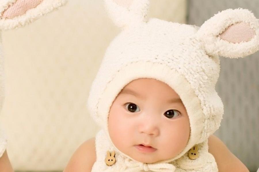 Baby wearing rabbit suit with hood.