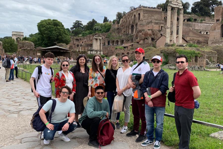 A group of students standing together in front of ancient building ruins.