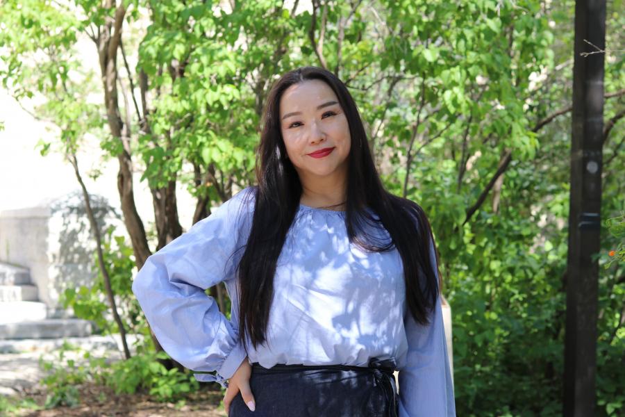 Headshot of Hee Jung Serenity Joo standing in front of green trees outside of Tier Building.