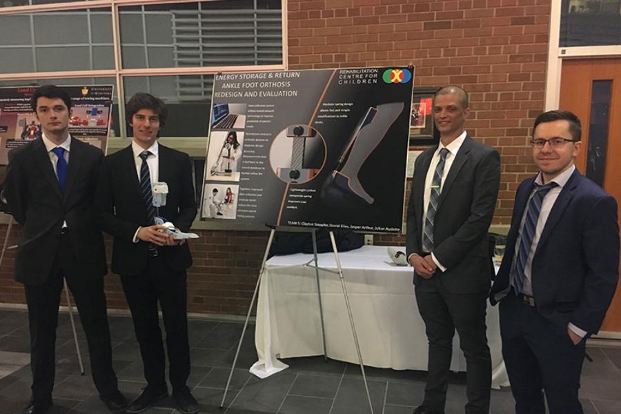 A team stands together beside their final capstone poster during the 2018 Mechanical Engineering Design Reception Evening.