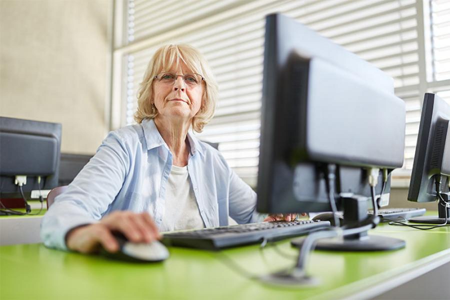 older adult woman soing work on a computer