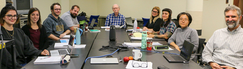 Students and faculty in the Archival Studies program, 2019-2020, sitting around a seminar table.