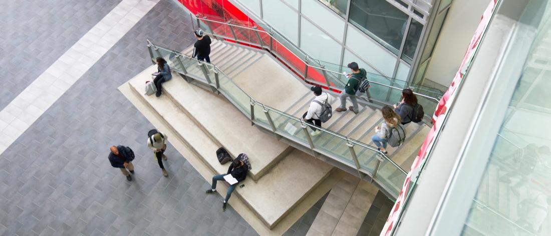 An elevated view of a busy staircase in the interior of the Engineering and Information Technology Complex.