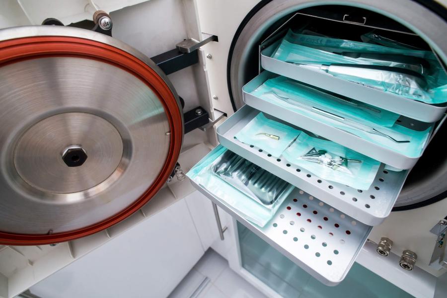 Surgical instruments lying in an autoclave tray.
