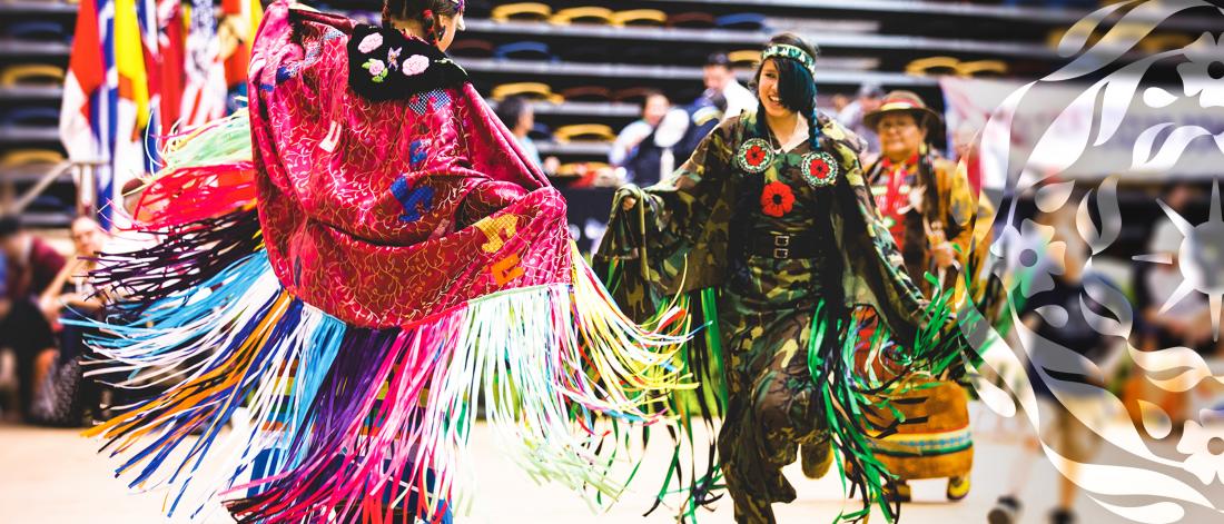 Dancers in colourful regalia dancing together at pow wow