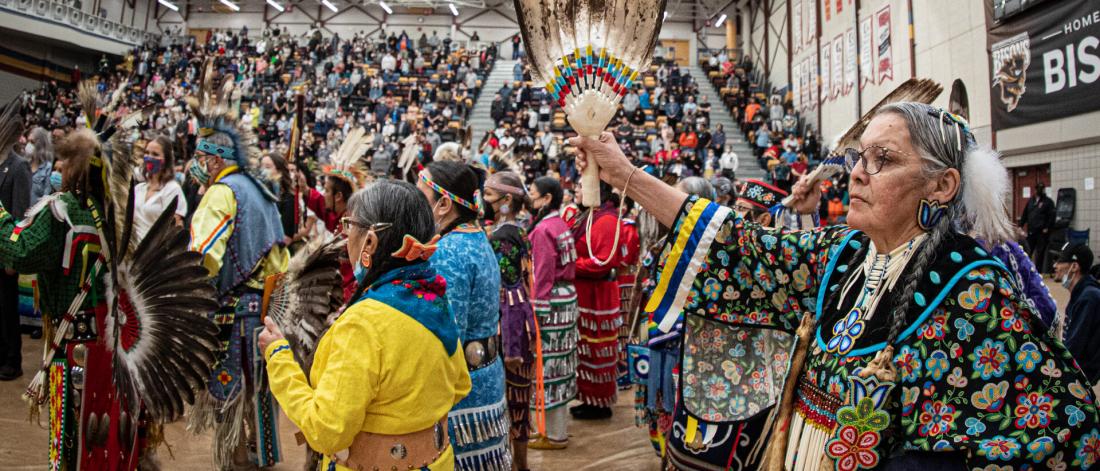 Dancers in colourful regalia participating in a Grand Entry at pow wow.