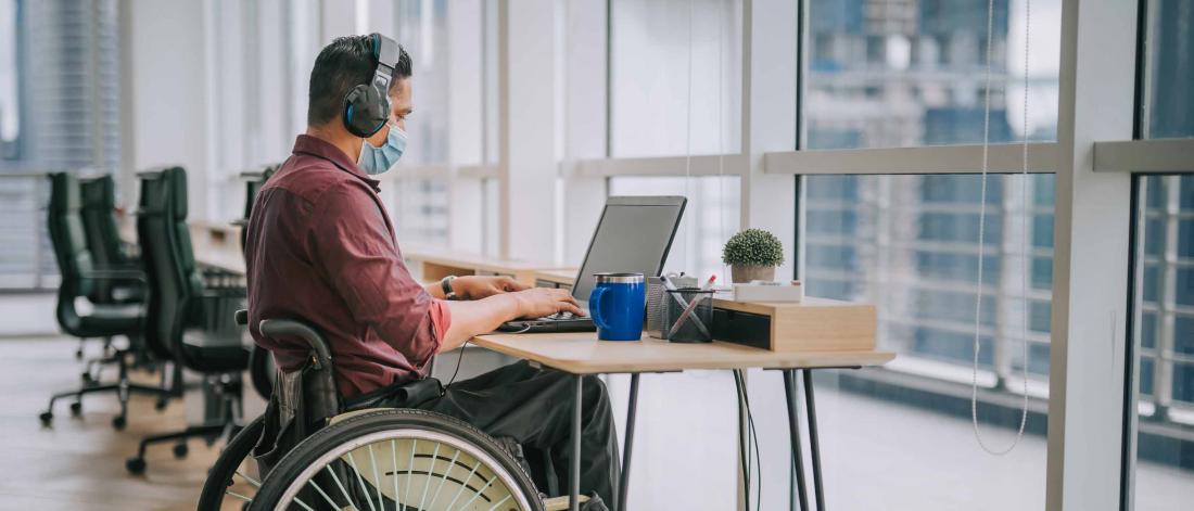 Researcher in wheelchair at laptop