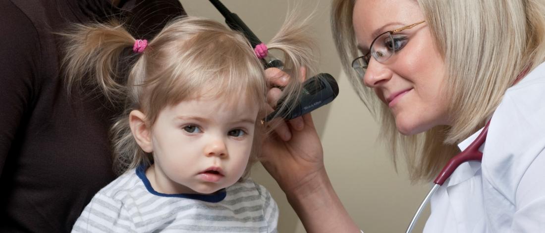 Physician examines child's ear.