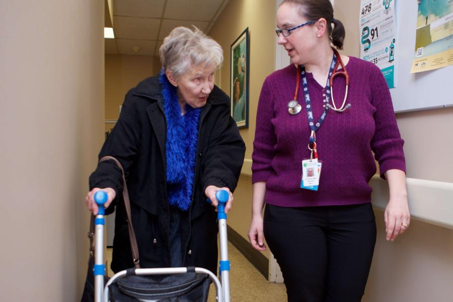 Physician walks with a senior citizen.