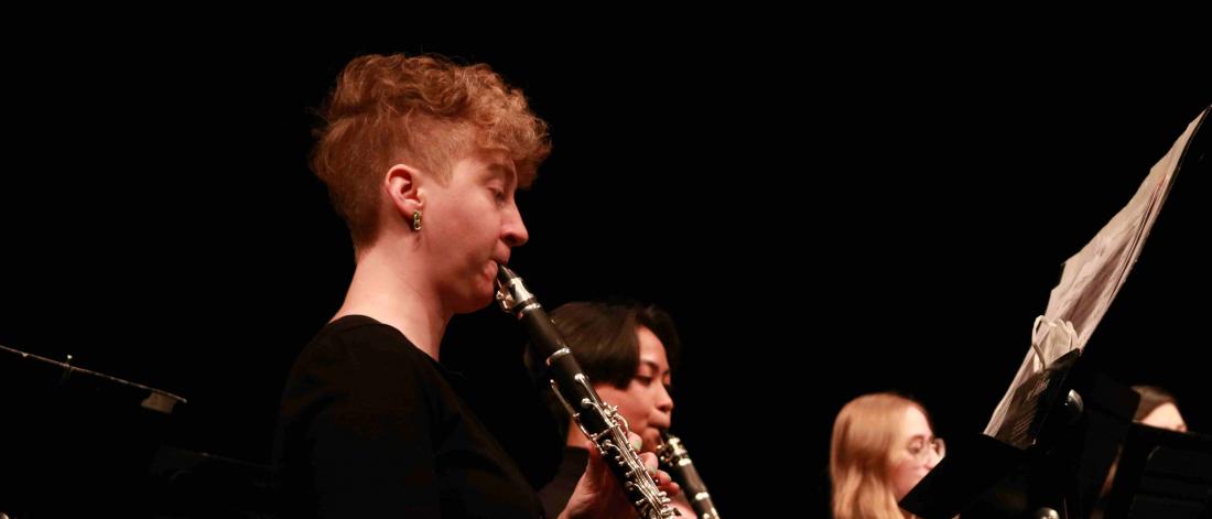 Student musicians play clarinet in concert.