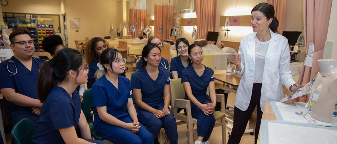 Nursing students participating in a clinical simulation session led by an instructor.
