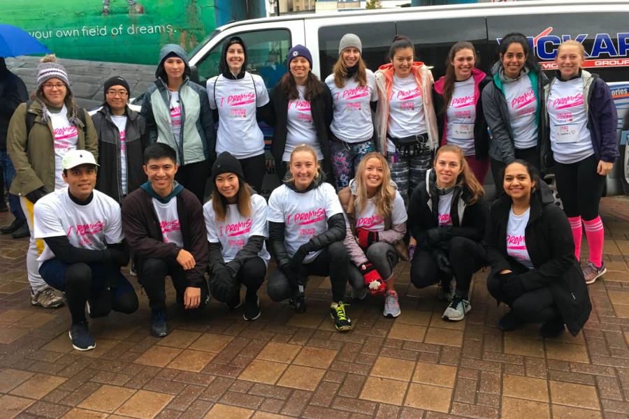 A group of pharmacy students huddle together for a photo wearing the same team tshirts for Canadian Cancer Society's Run for a Cure.
