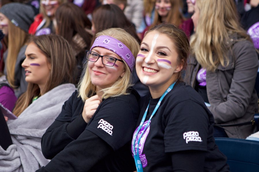 Two female University of Manitoba students showing off their team spirit at a Bisons Football game.