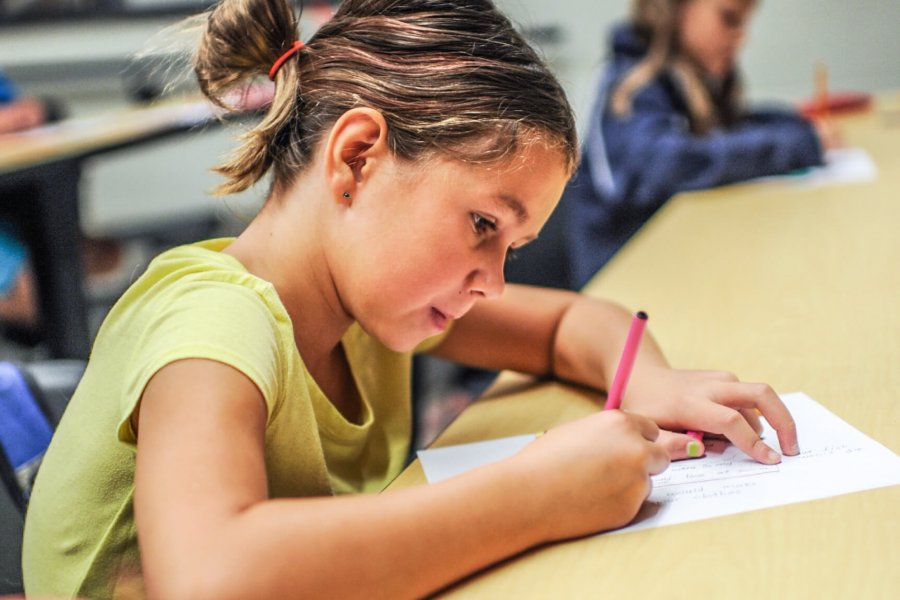 A child colouring at a desk.