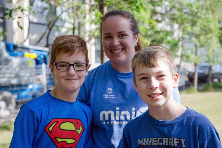 Two Mini U juniors pose for a photo with their leader.