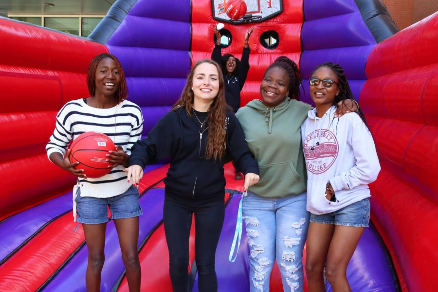 Five student residents play basketball in a bouncy castle.