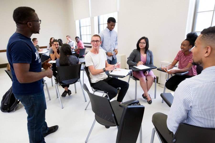 Students seated in circles receive instruction during a graduate student workshop.