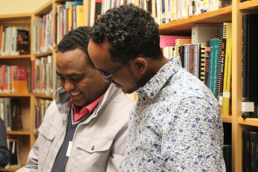 Two social work students talking in a library.