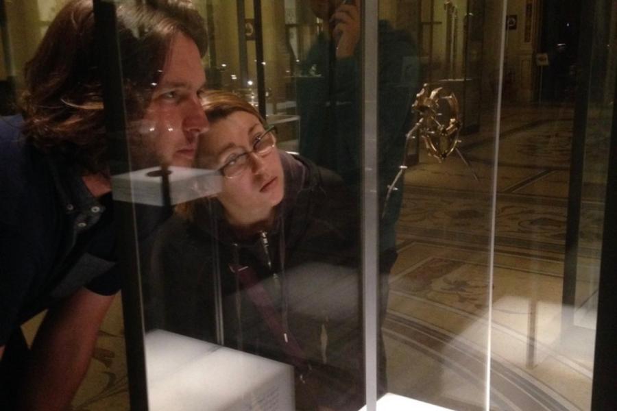 two people looking into glass case with artifact