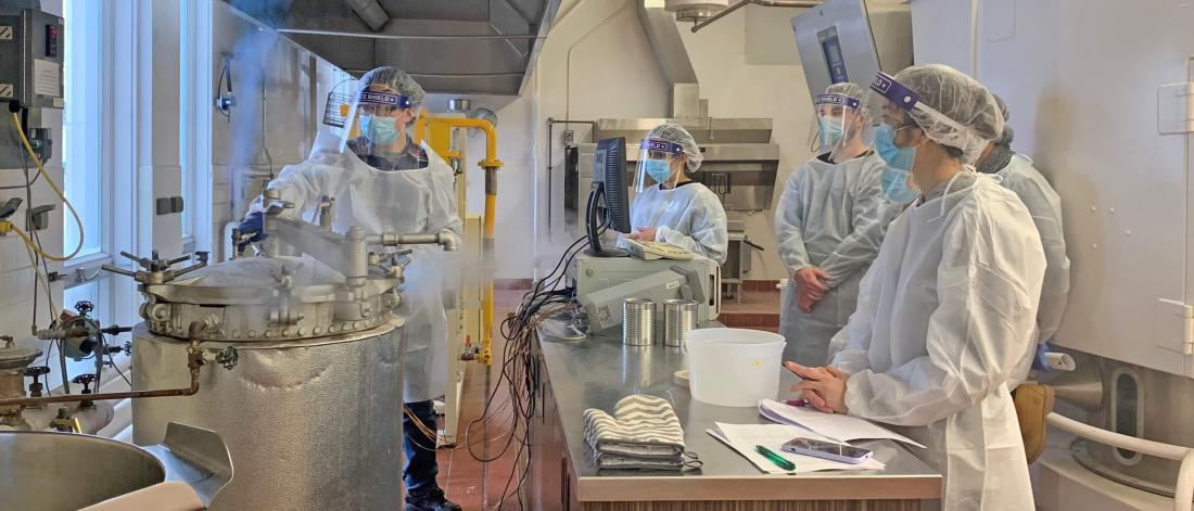 Students work in the pilot plant during a canning lab.