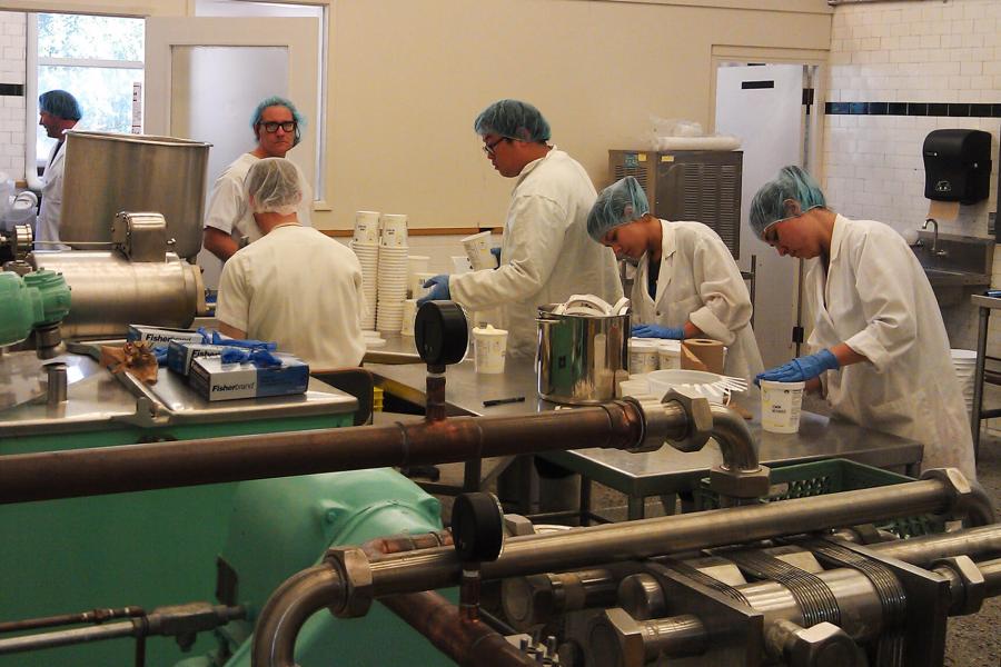 Students in lab coats work in the dairy pilot plant.