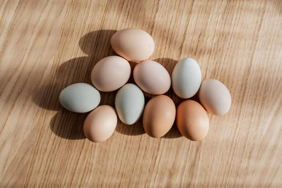 Ten eggs on a wooden table.