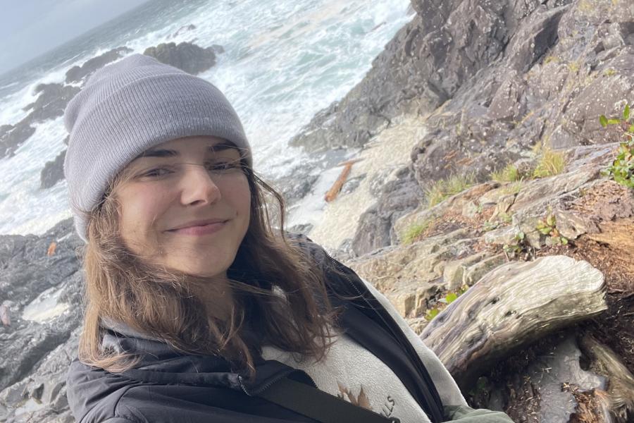 A photo of Shayla Woodland in front of rocky ocean