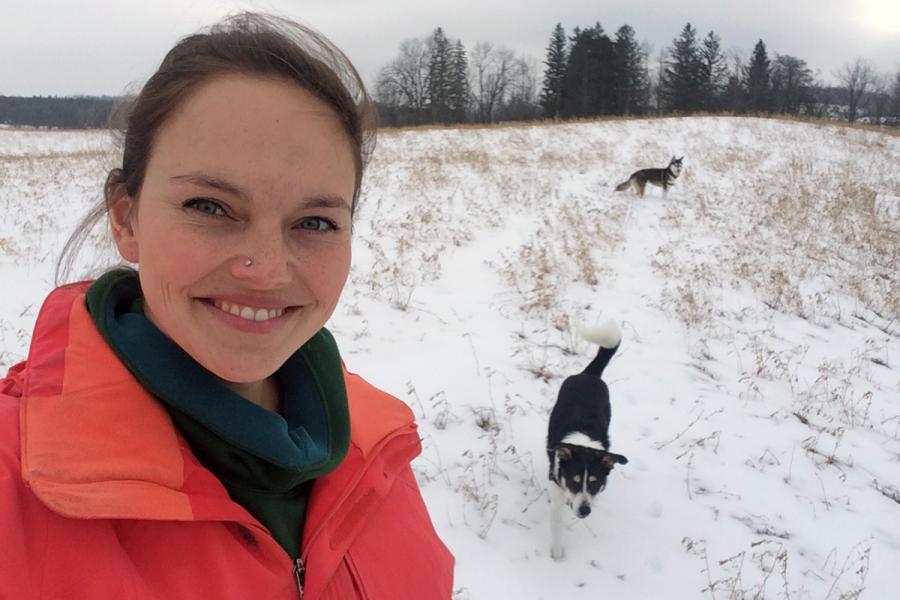 Dr Meagan King in a field with her dogs
