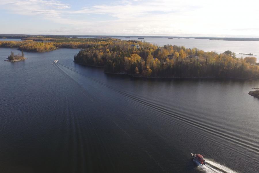 boats traveling on a lake through islands covered in trees