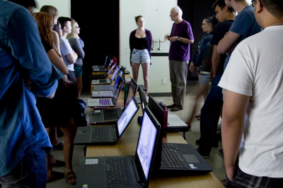 students standing in rows along a table