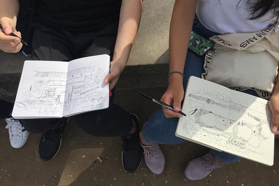 students holding sketch books open