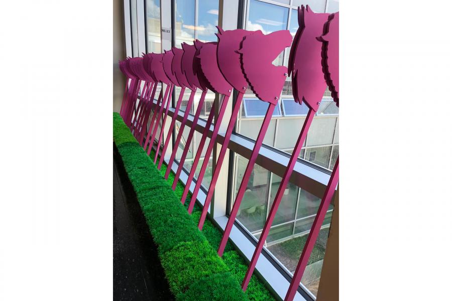 pink unicorn heads on sticks leaning against a window
