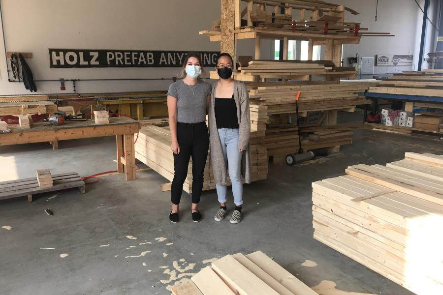 Carmen and Brooke stand in Holz Construction workshop.