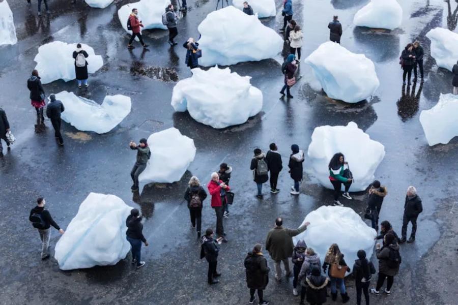 Human sized blocks of ice melting while poeple pose