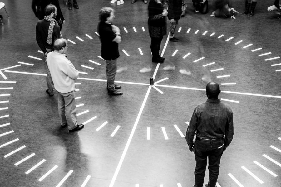 People standing still in a drawn clock on the floor