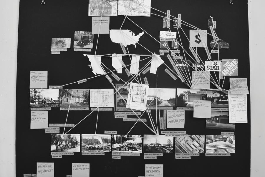 Black and white photo of board with images and string.