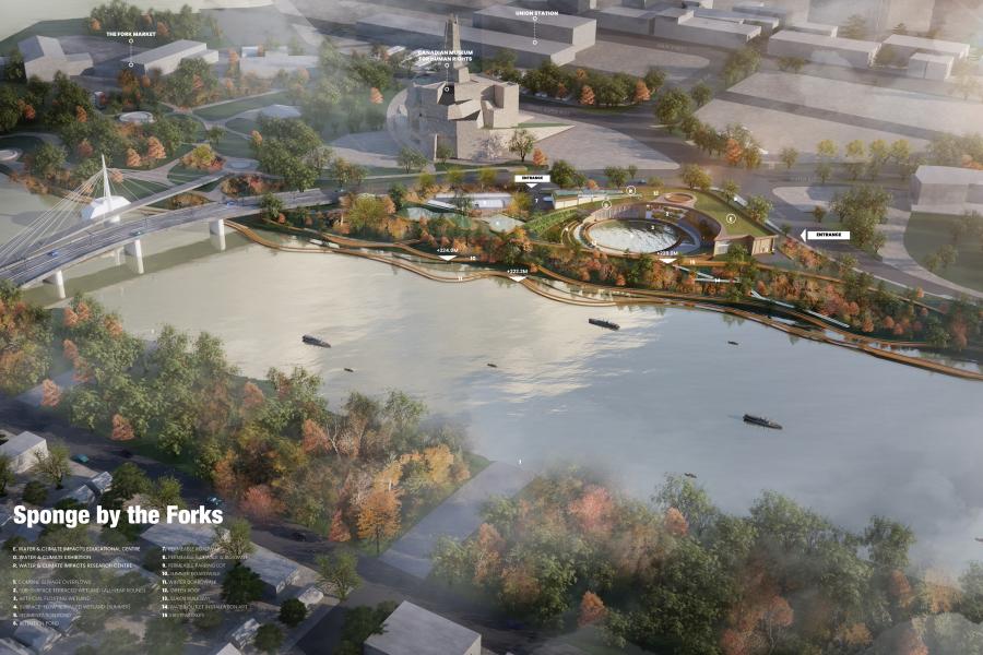 Aerial view of a riverfront park with dense autumn trees, curved pathways, and a circular structure. A bridge spans the river, dotted with small boats, near urban buildings.