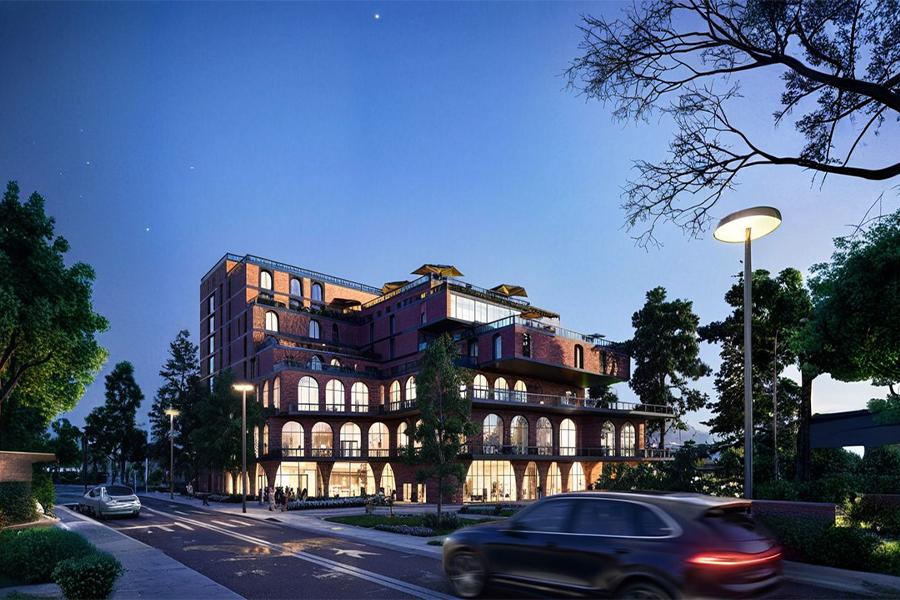 Modern building with arched windows and brick exterior, set against a twilight sky. Trees and a passing car create a tranquil urban scene.
