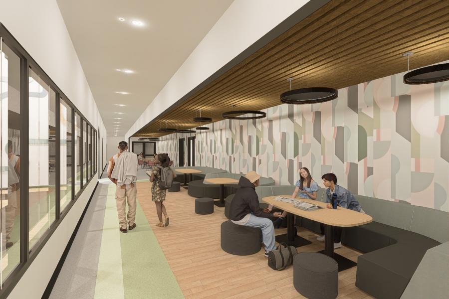 A modern hallway with wood ceilings and patterned walls. People are sitting at tables, reading or chatting, creating a relaxed and social atmosphere.