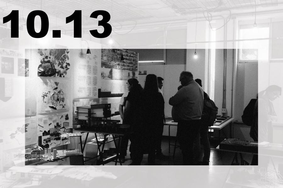 Black-and-white art exhibition in a studio, where visitors view collages and prints amid tables, hanging lights, and industrial fixtures.