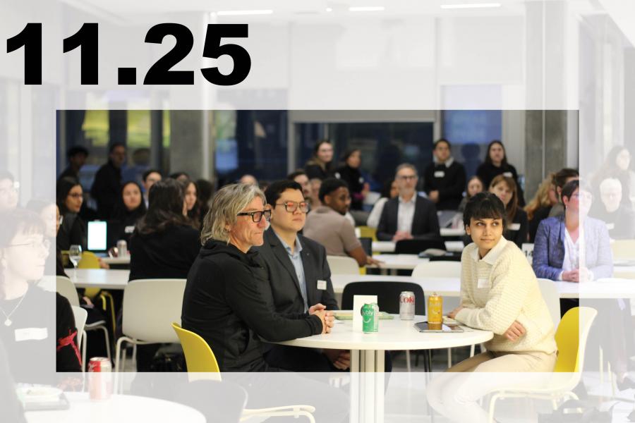 A bright conference room with diverse attendees; three colleagues sit at a table in front, conveying a focused, collaborative atmosphere.