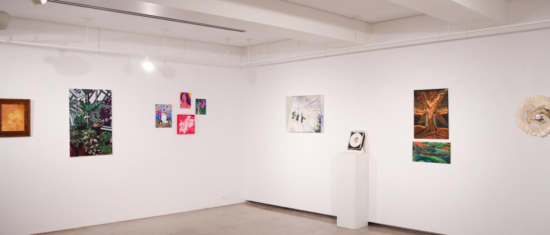 Interior view of the School of Art Student Gallery with paintings and mixed-media artworks displayed on white gallery walls.