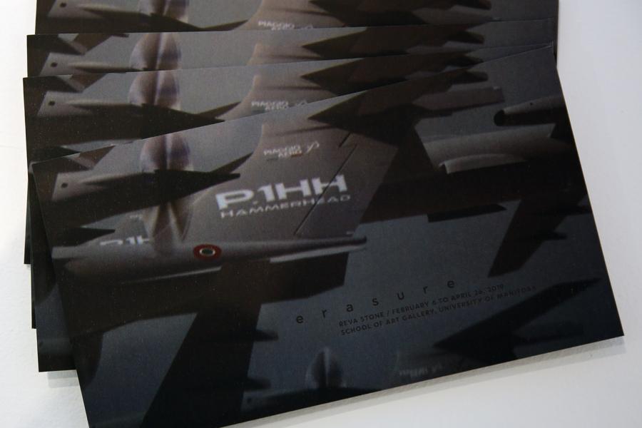 Four horizontal books faned out on a white back ground. The cover is dark abstract forms of browns, greys, and blue. 