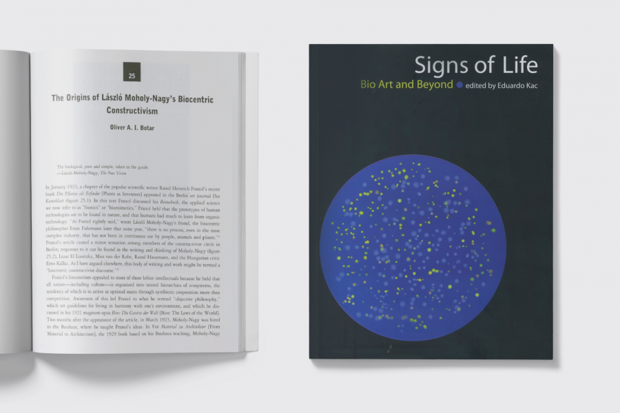 Book cover reading "Signs of Life Bio Art and Beyond" beside an open book with article text too small to read.