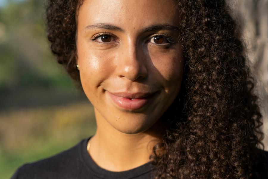  Lillian O’Brien Davis wearing a black crew neck shirt looks todarwds the camera smiling. 