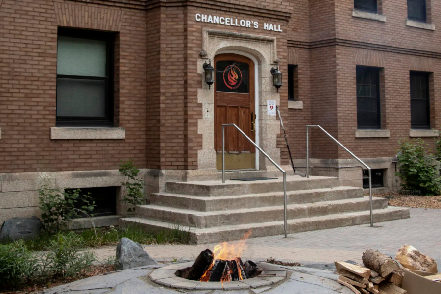Entrance of Chancellor's Hall at the National Centre for Truth and Reconciliation, with a ceremonial fire burning in the foreground.